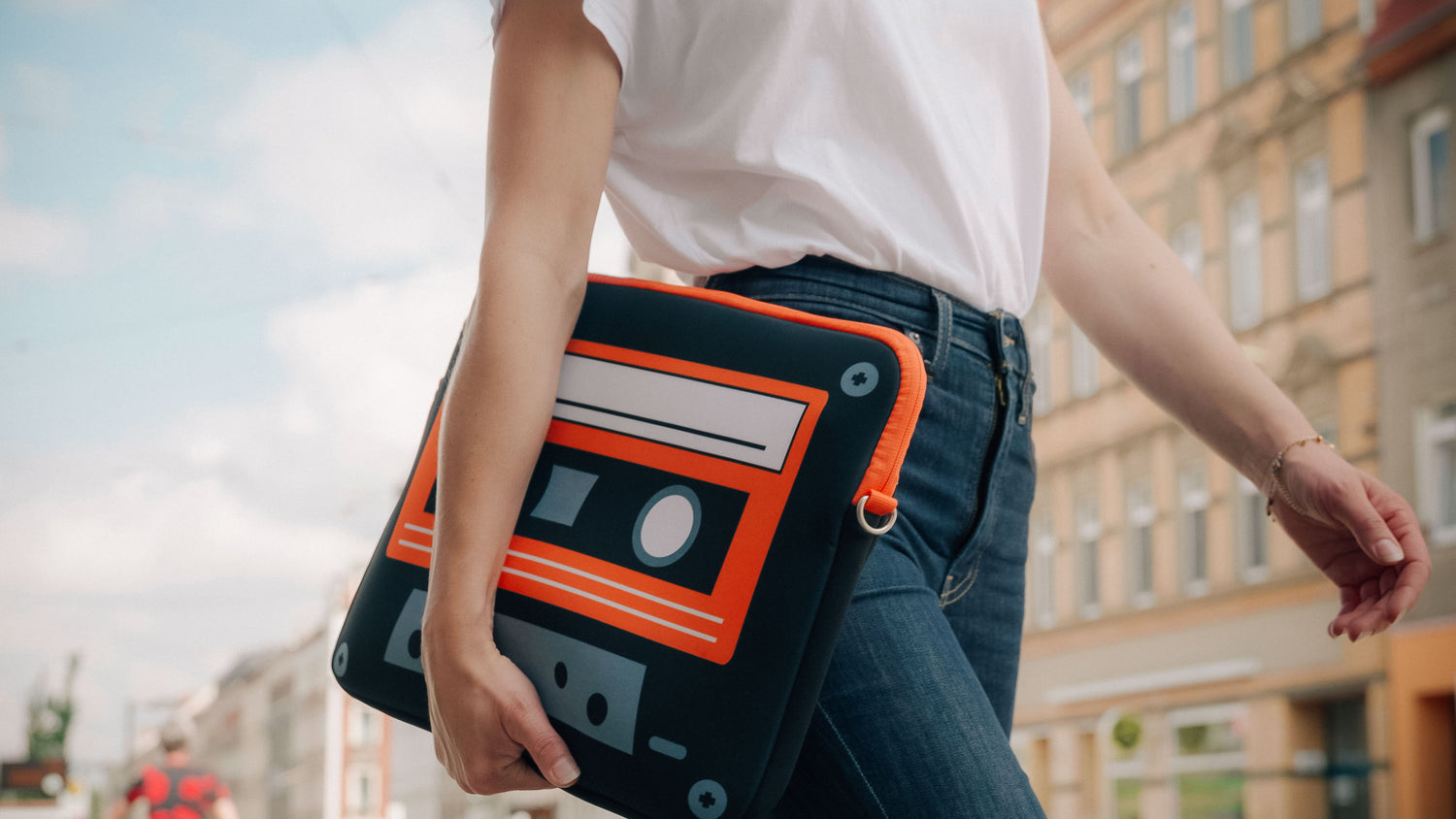 Frau geht in der Stadt mit LS 132 Old School Laptophülle spazieren